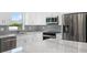 Modern kitchen with white cabinets, marble countertops, and stainless steel appliances at 10317 Gulfstream Blvd, Englewood, FL 34224