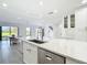 Bright kitchen with island sink and quartz countertops shows open floorplan and view to back patio at 1314 Pelican Creek Xing # 1314, St Petersburg, FL 33707