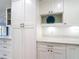 A modern kitchen with white cabinets, quartz countertops, stainless steel appliances, and ample storage space at 1314 Pelican Creek Xing # 1314, St Petersburg, FL 33707