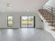 Open-concept living room featuring tile flooring, a modern staircase, and a sliding door to the outdoors at 1314 Pelican Creek Xing # 1314, St Petersburg, FL 33707
