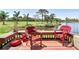 Outdoor patio with red wicker furniture overlooking a picturesque view of the green golf course and river at 1314 Pelican Creek Xing # 1314, St Petersburg, FL 33707