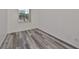 Spacious bedroom with grey wood-look floors and window at 633 Tremont Greens Ln # 16, Sun City Center, FL 33573