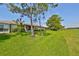 Private backyard with grassy area, trees, and screened patio at 633 Tremont Greens Ln # 16, Sun City Center, FL 33573
