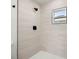 Modern walk-in shower with cream tiles, and black hardware at 7422 S 34Th Ave, Tampa, FL 33619