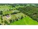 Aerial view of a house with a large green lawn and surrounding trees at 36431 Florrie Mae Ln, Dade City, FL 33523