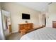 Bedroom with king-size bed, large mirror, and wooden dresser with TV at 36431 Florrie Mae Ln, Dade City, FL 33523