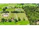 Aerial view of a house with a large green lawn and surrounding trees at 36431 Florrie Mae Ln, Dade City, FL 33523