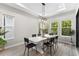 Bright dining room with white table and black chairs, near sliding doors at 1039 Seagrape Dr, Ruskin, FL 33570