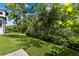 Landscaped backyard with lush greenery and a paved walkway at 1039 Seagrape Dr, Ruskin, FL 33570