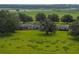 Expansive property featuring a charming brick home with a lush, green lawn and mature trees at 34868 Prospect Rd, Dade City, FL 33525