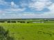 Vast green field with a small pond and distant trees at 34868 Prospect Rd, Dade City, FL 33525