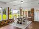 Bright dining area with farmhouse style table and chairs, and sunroom views at 34868 Prospect Rd, Dade City, FL 33525