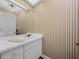 Small bathroom with white vanity and striped wallpaper at 34868 Prospect Rd, Dade City, FL 33525