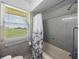 Bathroom with gray tile, a tub, and a window with a view at 34868 Prospect Rd, Dade City, FL 33525