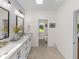 Bright bathroom boasts double vanity, marble countertop, and access to a small restroom at 34868 Prospect Rd, Dade City, FL 33525