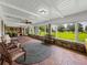 Sunroom features brick floors, comfortable seating, and serene views at 34868 Prospect Rd, Dade City, FL 33525