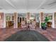 Sunroom features brick floors and comfortable seating with views at 34868 Prospect Rd, Dade City, FL 33525