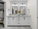 Elegant bathroom with double vanity, marble counters, and a walk-in closet at 34868 Prospect Rd, Dade City, FL 33525