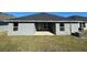 Covered patio with grey concrete flooring and grassy backyard at 13260 Ogden Glade Rd, Dade City, FL 33525