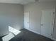 Spacious bedroom with neutral walls, carpet flooring, and two doors at 13260 Ogden Glade Rd, Dade City, FL 33525