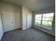 Bedroom with double doors, window, and grey carpet at 13260 Ogden Glade Rd, Dade City, FL 33525