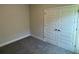Bright bedroom featuring grey carpet and double doors at 13260 Ogden Glade Rd, Dade City, FL 33525