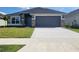 Charming single-story home showcasing a gray facade, stone accents, and a spacious two-car garage at 13260 Ogden Glade Rd, Dade City, FL 33525