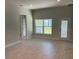 Spacious living area with tile floors, large window, and access to a bathroom at 13260 Ogden Glade Rd, Dade City, FL 33525
