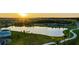 Sunset view of a community lake with walking paths at 9293 Rally Spring Loop, Wesley Chapel, FL 33545