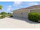 Three-car garage with light beige doors and Spanish tile roof at 9336 Melody Cir, Port Charlotte, FL 33981
