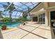 Inviting pool area with screened enclosure, brick pavers, and lush landscaping at 9336 Melody Cir, Port Charlotte, FL 33981