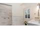 Elegant bathroom with marble shower, double vanity, and large window at 15704 Cheston Ct, Tampa, FL 33647