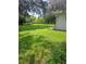 Large grassy backyard with mature trees and a shed at 5023 6Th St, Zephyrhills, FL 33542