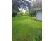 Large grassy backyard with mature trees and a shed at 5023 6Th St, Zephyrhills, FL 33542