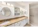 Bright bathroom featuring a double vanity with granite countertops and a tiled shower at 1145 Almondwood Dr, Trinity, FL 34655