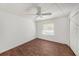 Bright bedroom featuring wood floors, a ceiling fan, a window with blinds, and a closet with white doors at 1145 Almondwood Dr, Trinity, FL 34655