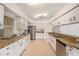 Spacious kitchen with white cabinets, granite countertops, and stainless steel appliances at 1145 Almondwood Dr, Trinity, FL 34655