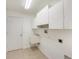 Well-lit laundry room with ample white cabinets and a convenient utility sink at 1145 Almondwood Dr, Trinity, FL 34655