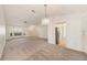 Inviting living room with neutral carpet and an elegant chandelier, seamlessly connected to the kitchen at 1145 Almondwood Dr, Trinity, FL 34655