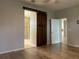 Main bedroom with hardwood floors and barn door leading to the bathroom at 10308 Holland Rd, Riverview, FL 33578