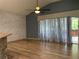 Living room with hardwood floors, stone accent wall, and sliding glass doors at 10308 Holland Rd, Riverview, FL 33578