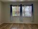 Bedroom with hardwood floors, neutral walls, and blue curtains at 10308 Holland Rd, Riverview, FL 33578