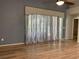 Living room with hardwood floors, stone accent wall, and sliding glass doors at 10308 Holland Rd, Riverview, FL 33578