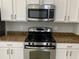 Stainless steel appliances and granite countertops in kitchen at 10308 Holland Rd, Riverview, FL 33578