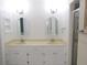 Bathroom featuring double sink vanity, modern mirrors, and a glass-enclosed shower at 2501 Lonigan Pl, Sun City Center, FL 33573