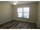 View of a light-filled bedroom, featuring a modern ceiling fan and stylish gray laminate flooring at 2501 Lonigan Pl, Sun City Center, FL 33573