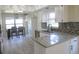 Kitchen features new floors, granite countertops, mosaic backsplash, and white cabinets at 2501 Lonigan Pl, Sun City Center, FL 33573