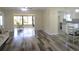 An open living room with new floors and a view of the kitchen area at 2501 Lonigan Pl, Sun City Center, FL 33573