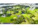 Aerial view showcasing a lush green golf course winding through a community with mature trees at 5733 Pawnee St, Zephyrhills, FL 33542