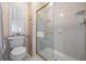 Well-lit bathroom equipped with glass shower enclosure, towel rack and a storage cabinet at 5733 Pawnee St, Zephyrhills, FL 33542